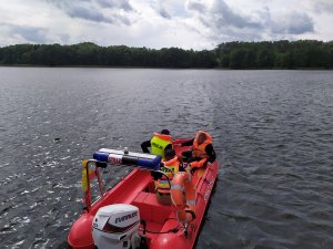 Funkcjonariusze odpływają motorówką na jezioro