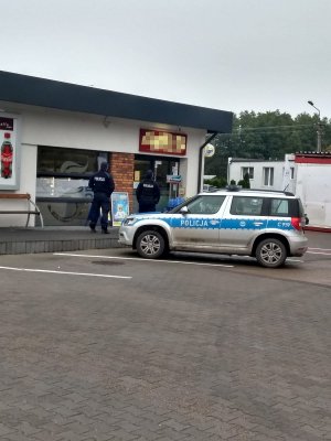 Policjanci kontrolują obowiązek zasłaniania ust i nosa na jednej ze stacji benzynowych