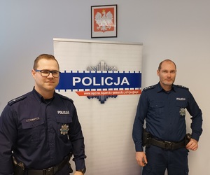 Dzielnicowi z Więcborka pozują do zdjęcia na tle loga sępoleńskiej policji. Z lewej strony mł.asp. Marek Piekut, z prawej st. asp. Przemysław Śledź.