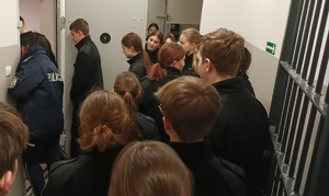 Uczniowie zwiedzają pomieszczenie dla osób zatrzymanych.